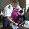 Fishburne Military School cadet assists a young student in building a rocket